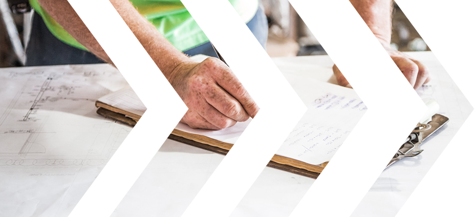 Close-up of a person examining architectural plans on a table.